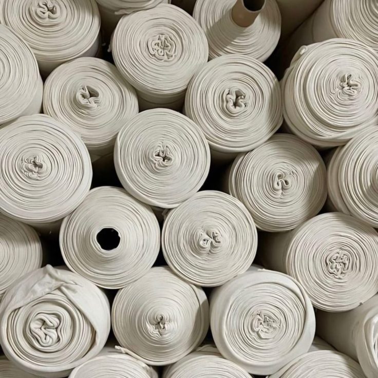 Vista superior dos rolos de tricoline 100% algodão prontos para confecção, armazenados lado a lado - Sou de Algodão.